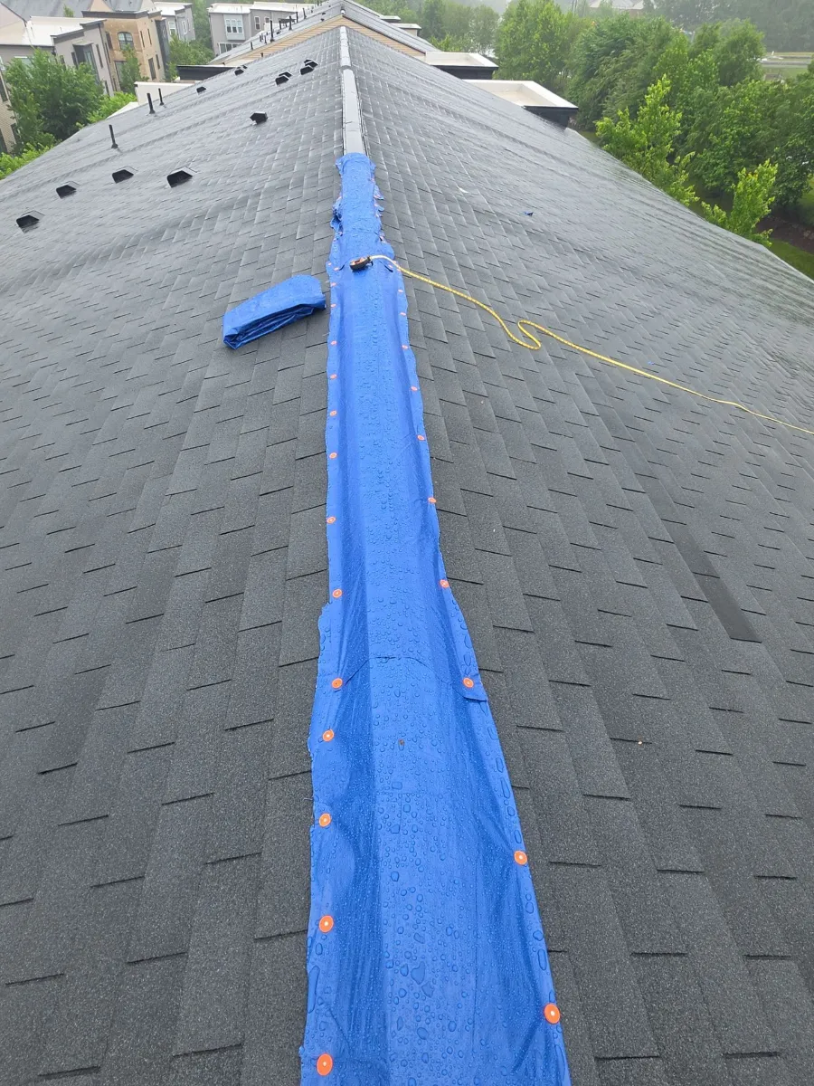 Emergency tarp covering the damaged ridge on a roof in Brambleton, VA