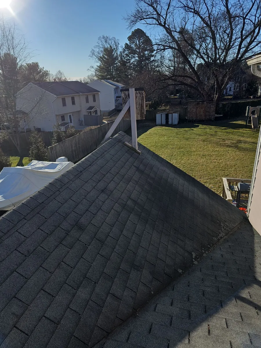 Aged dark gray shingle roof with a gable on a Purcellville, VA home before replacement